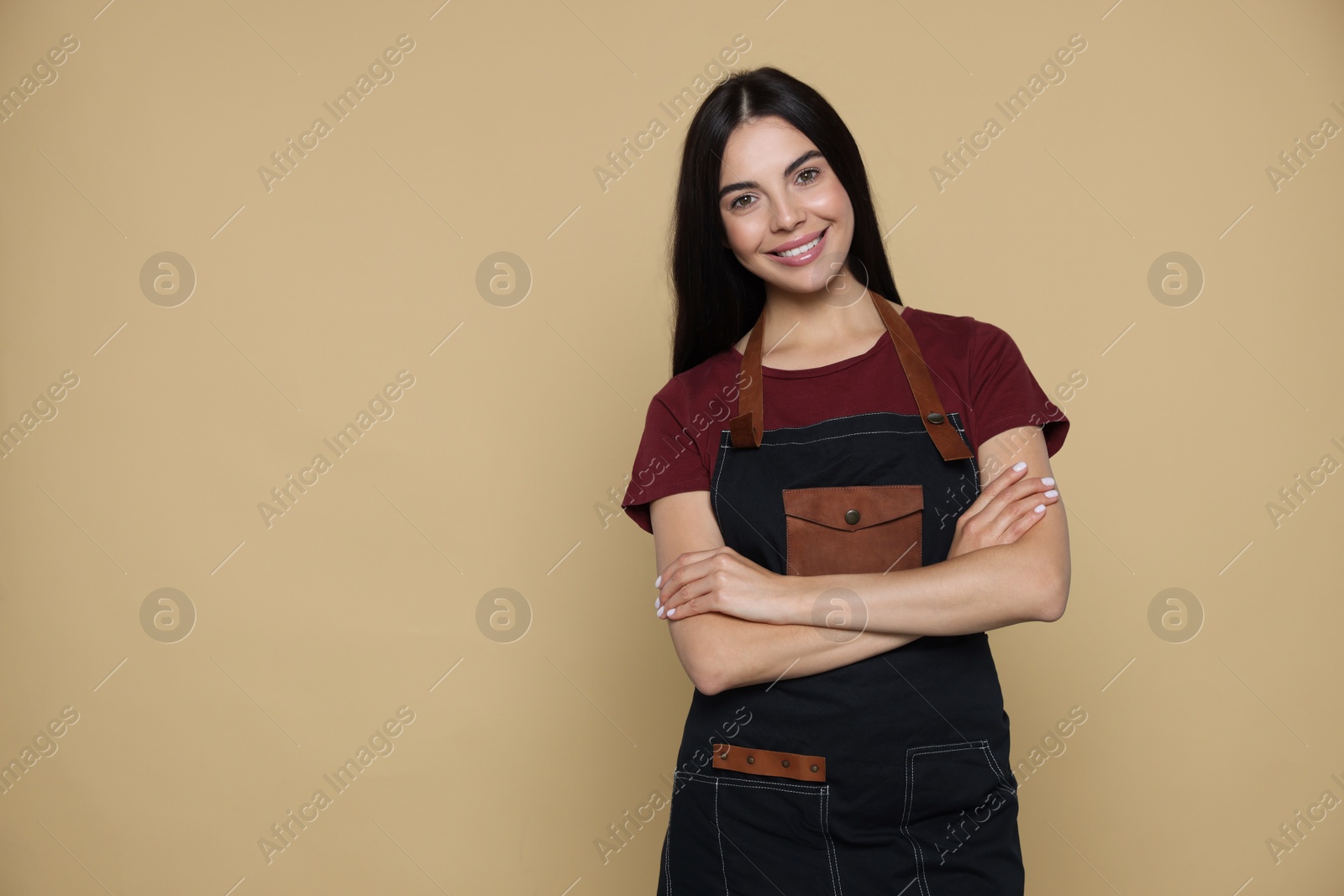 Photo of Portrait of happy hairdresser on beige background, space for text