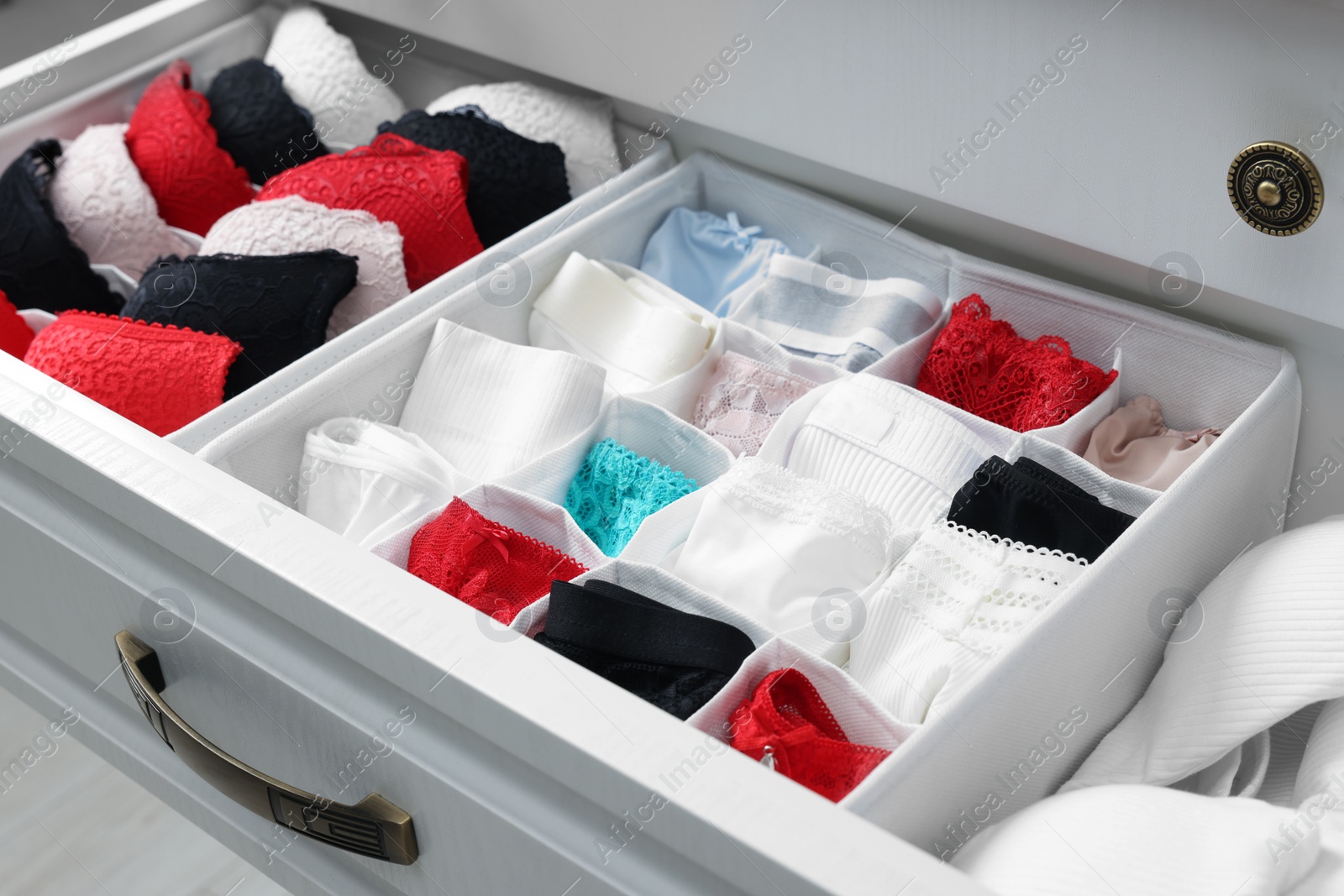 Photo of Organizers with beautiful women's underwear in drawer, closeup