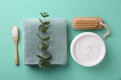 Photo of Jar of cream, body care products and eucalyptus branch on turquoise background, flat lay