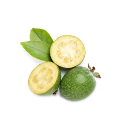 Cut and whole feijoas with leaves on white background, top view
