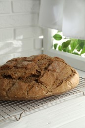 Photo of Freshly baked sourdough bread on white wooden table indoors