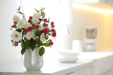 Photo of Vase with fresh flowers on table in kitchen. Space for text