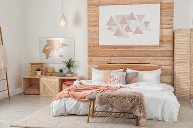 Photo of Stylish room interior with comfortable bed near wooden wall