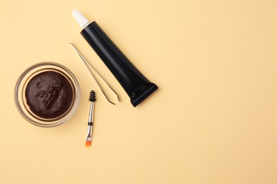 Flat lay composition with eyebrow henna and tools on beige background. Space for text