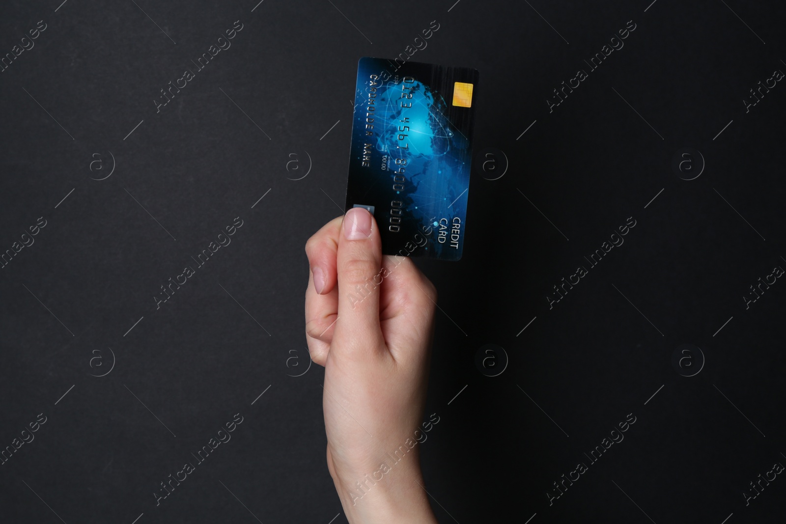 Photo of Woman holding credit card on black background, closeup