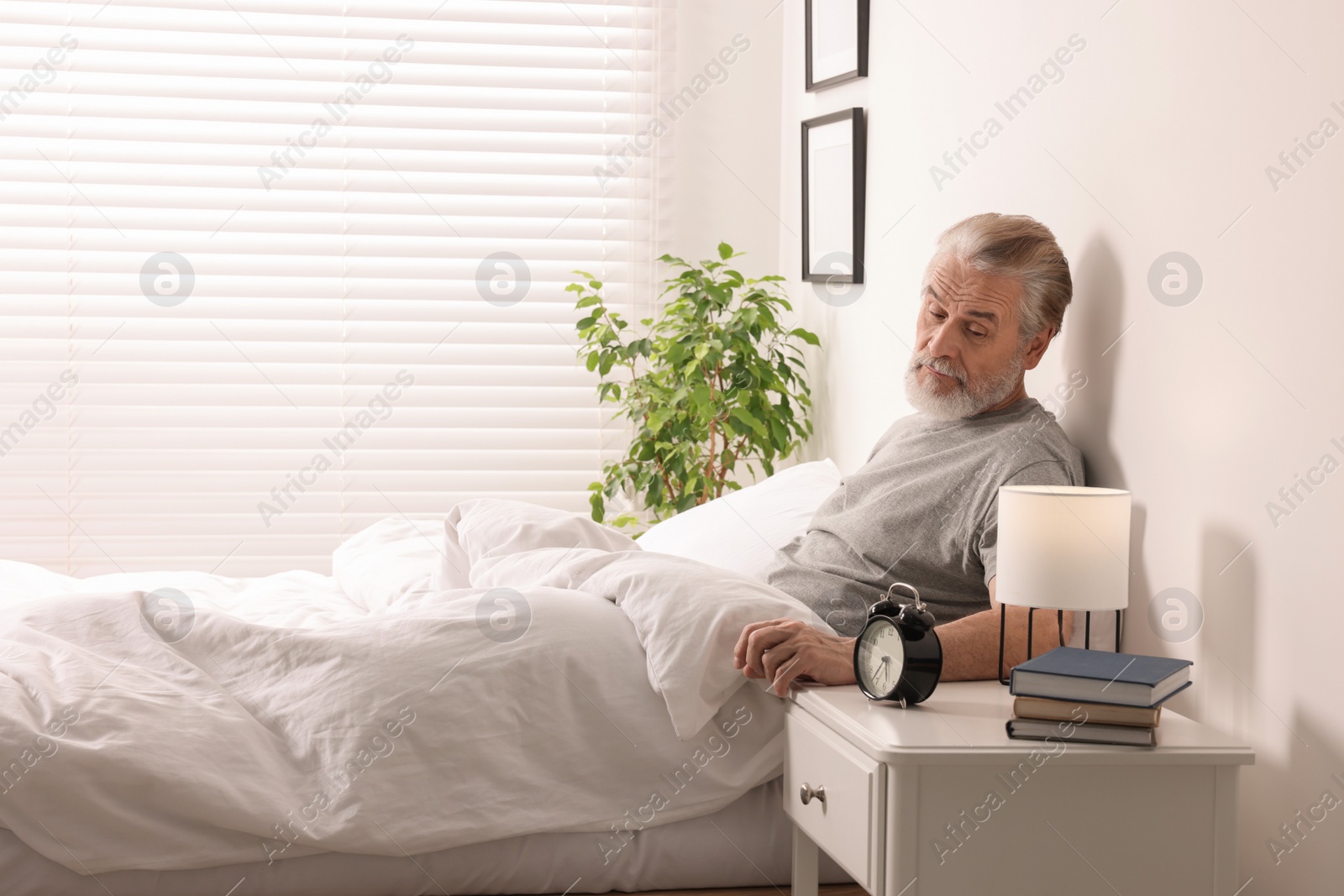 Photo of Sleepy senior man in bed at home