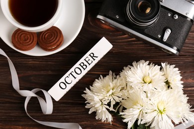 Photo of Flat lay composition with beautiful white chrysanthemum flowers and vintage camera on wooden table