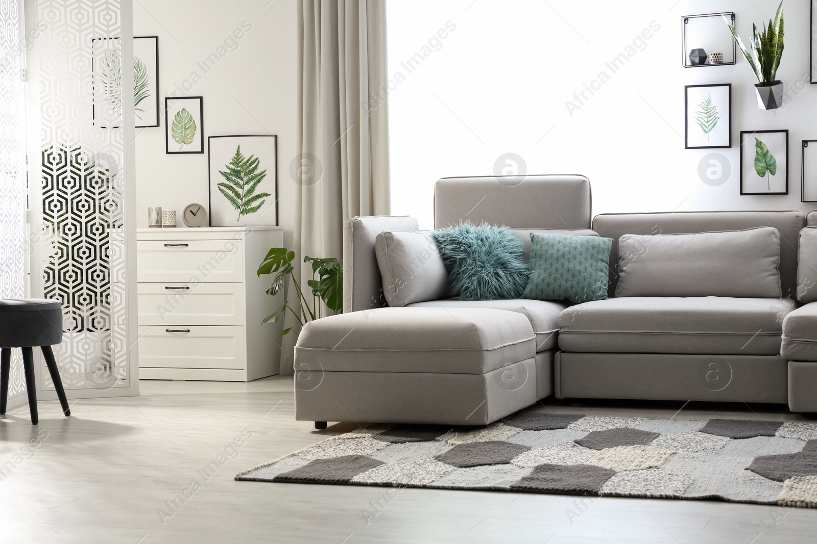 Photo of Comfortable large sofa in light room. Interior design