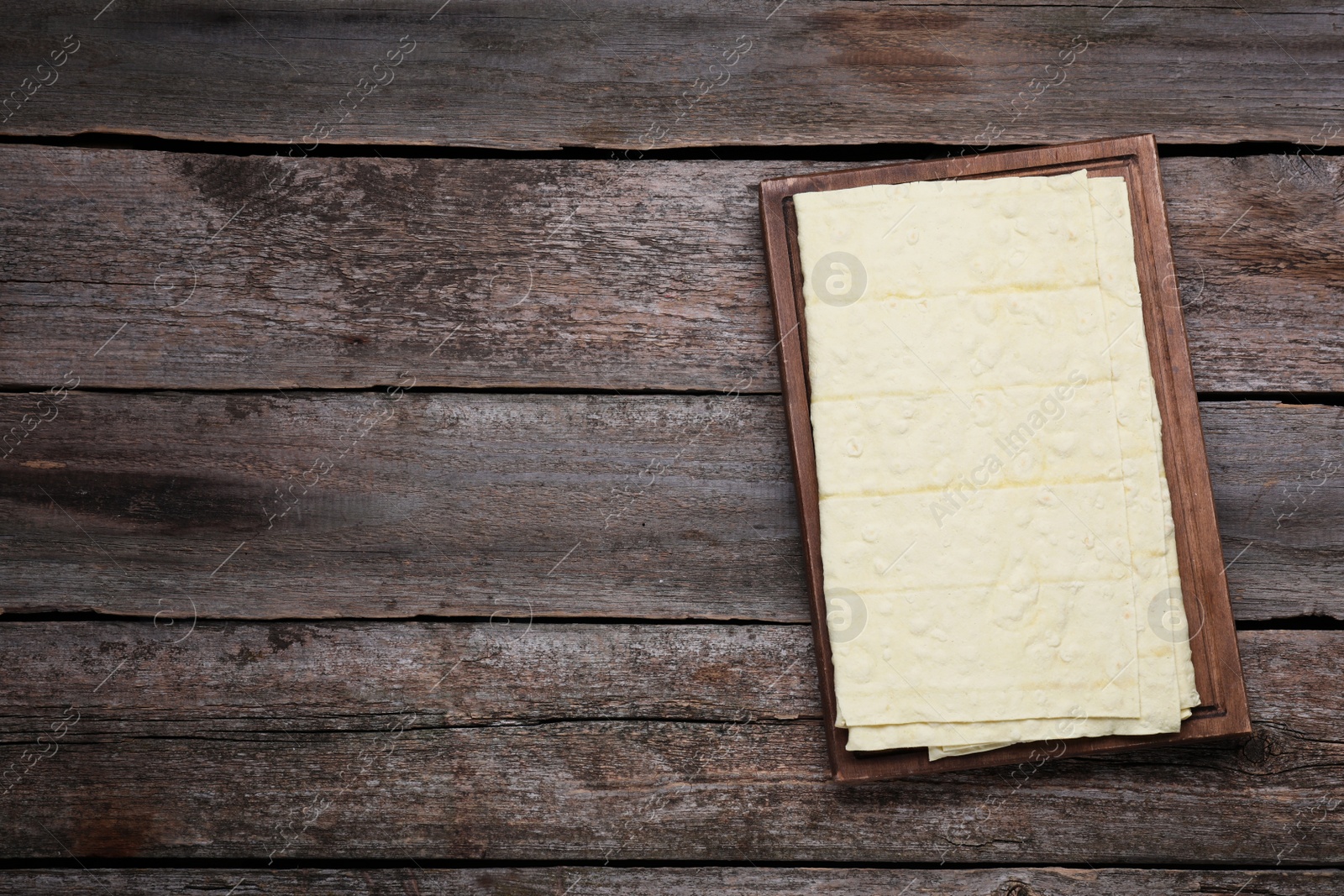 Photo of Delicious Armenian lavash on wooden table, top view. Space for text