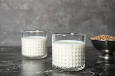 Photo of Glasses of hemp milk on grey table
