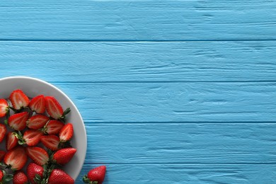 Food photography. Plate of delicious ripe strawberries on light blue wooden table, top view with space for text