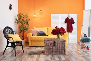 Elegant living room interior with yellow sofa and folding screen