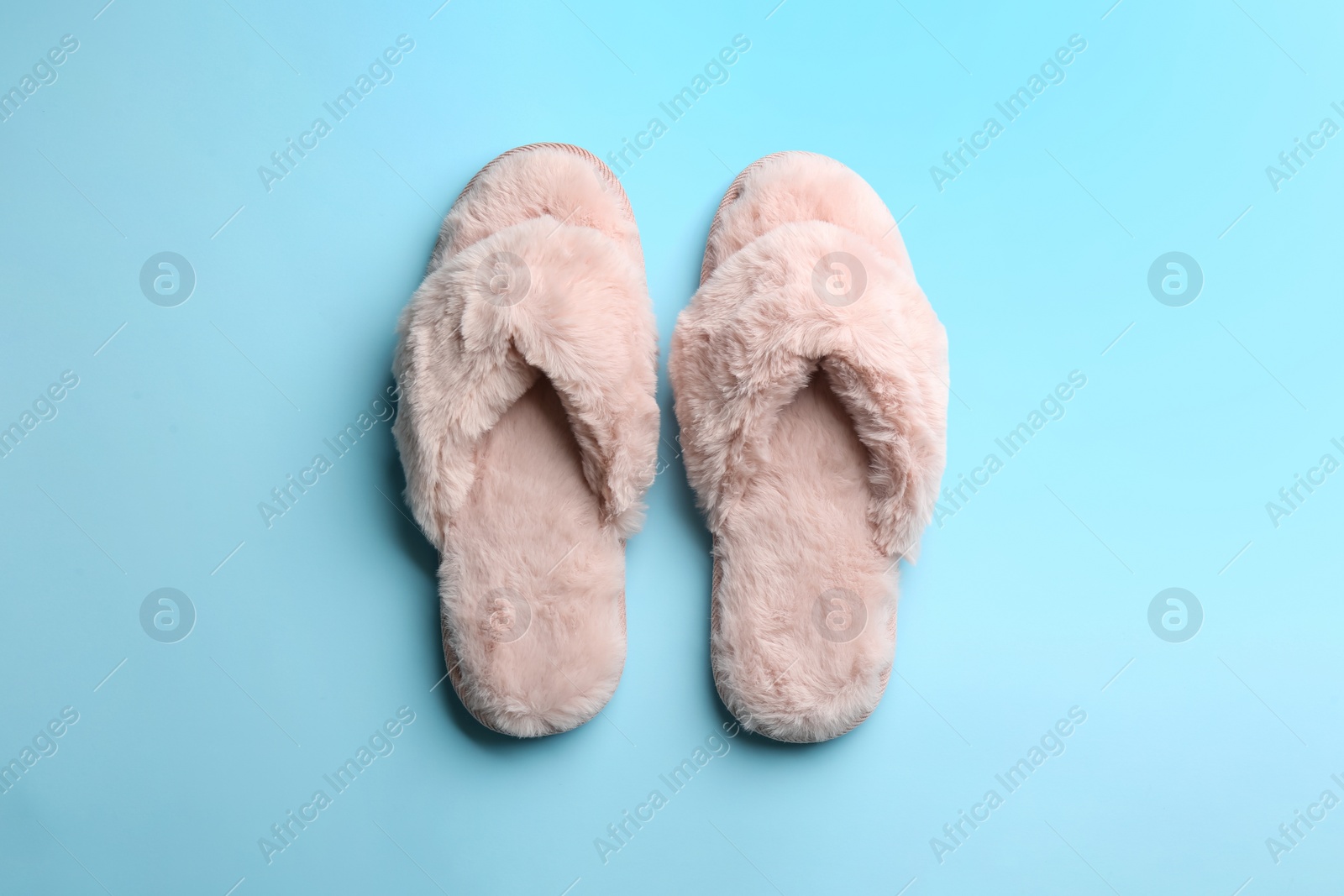 Photo of Pair of stylish soft slippers on light blue background, flat lay