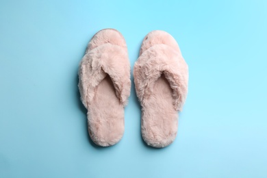 Pair of stylish soft slippers on light blue background, flat lay