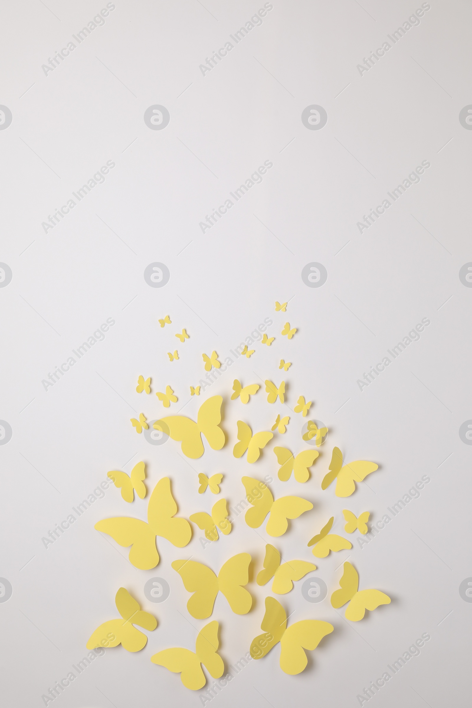 Photo of Yellow paper butterflies on white background, top view. Space for text