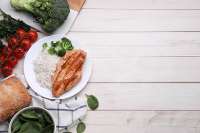 Photo of Grilled chicken breast and rice served with vegetables on wooden table, flat lay. Space for text