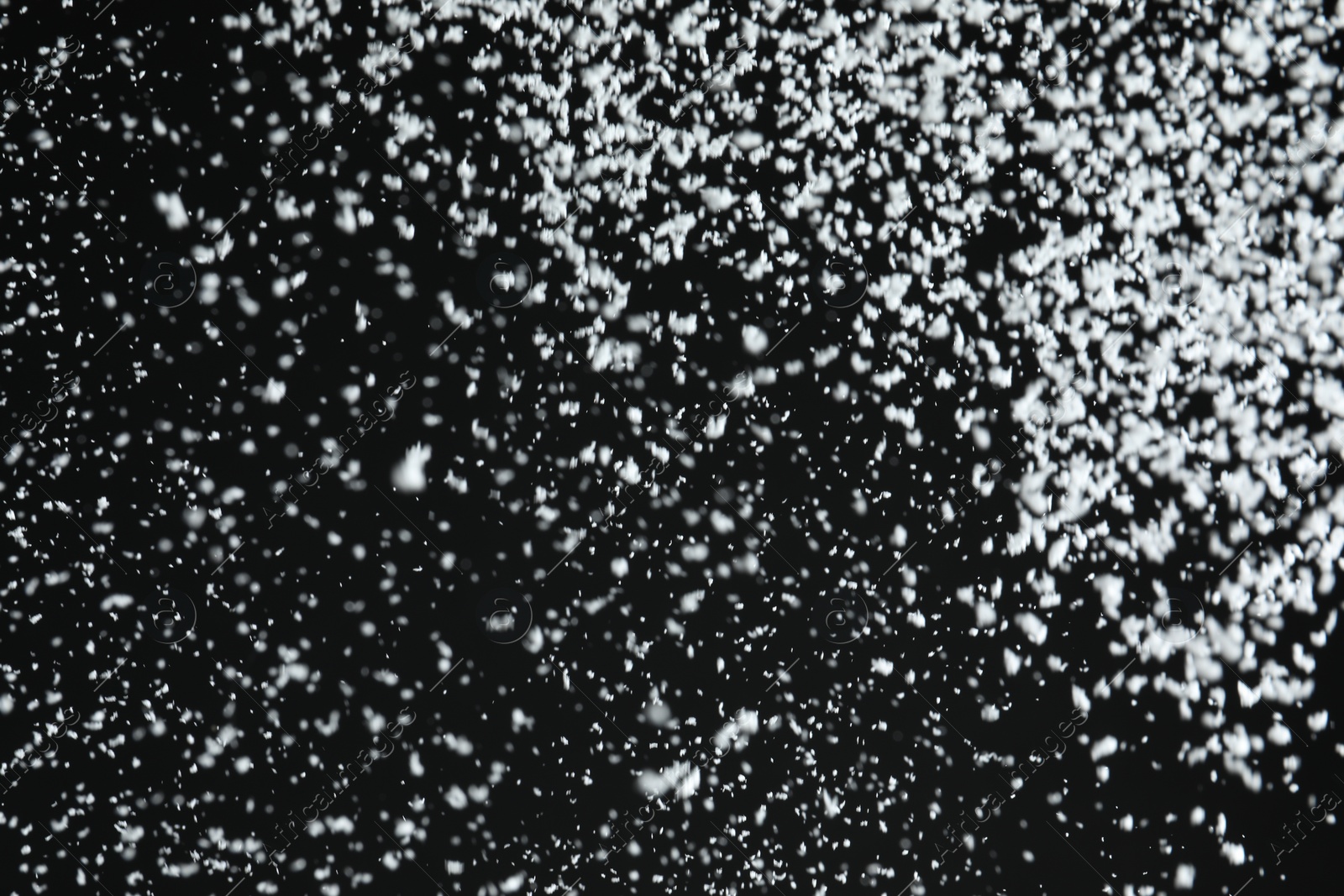 Photo of White snow falling down on black background