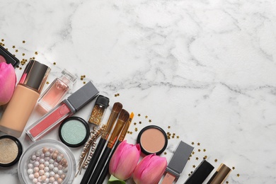 Photo of Makeup products and flowers on marble background, flat lay with space for text