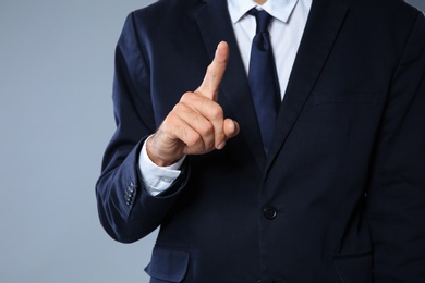 Businessman pointing on grey background, closeup of hand