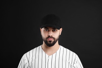 Photo of Man in stylish baseball cap on black background