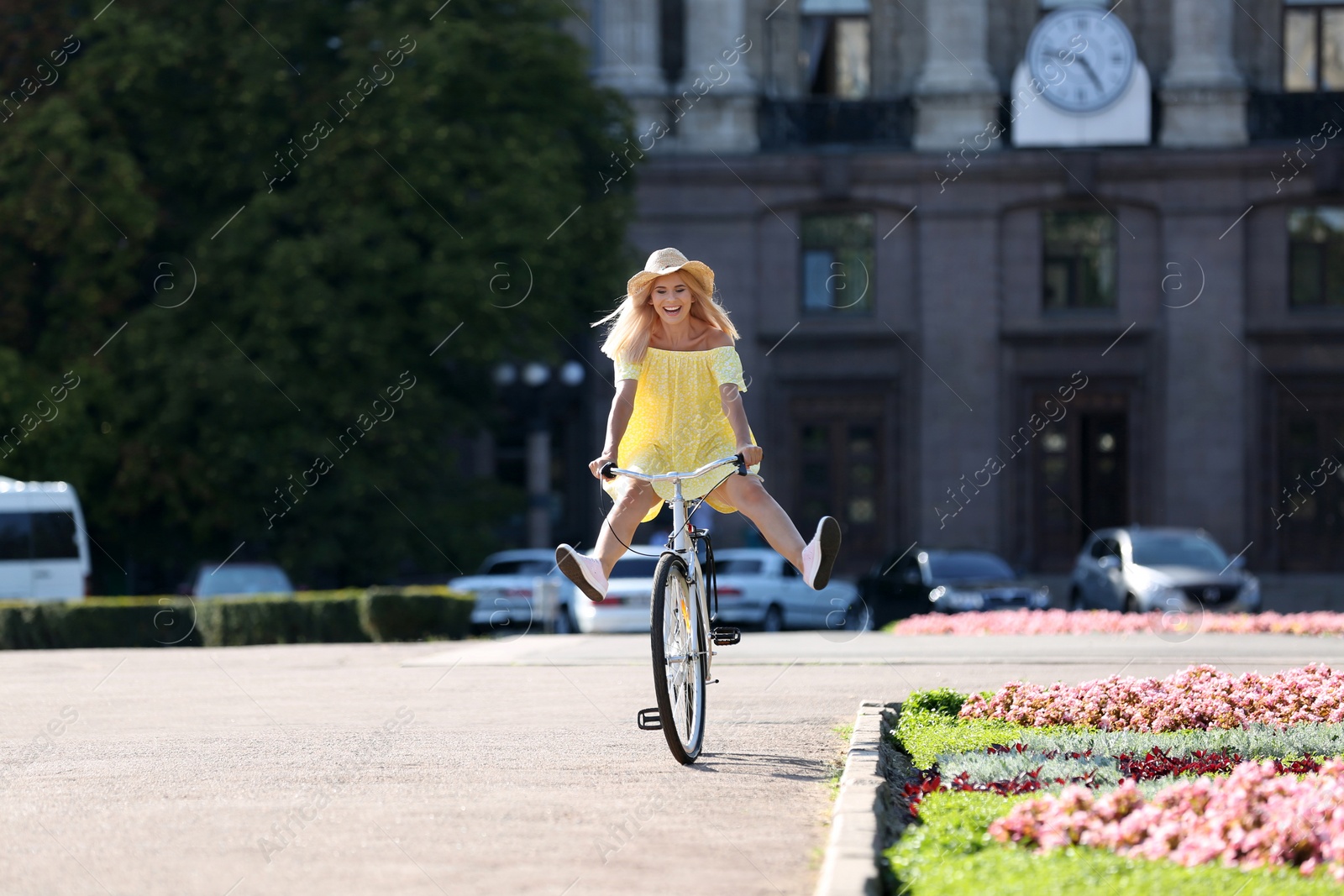 Photo of Beautiful happy woman riding bicycle on street