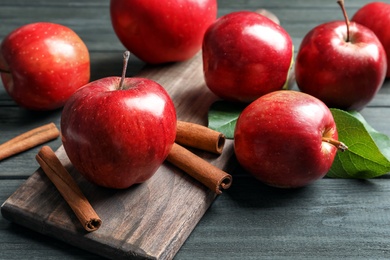 Photo of Fresh apples and cinnamon sticks on wooden table