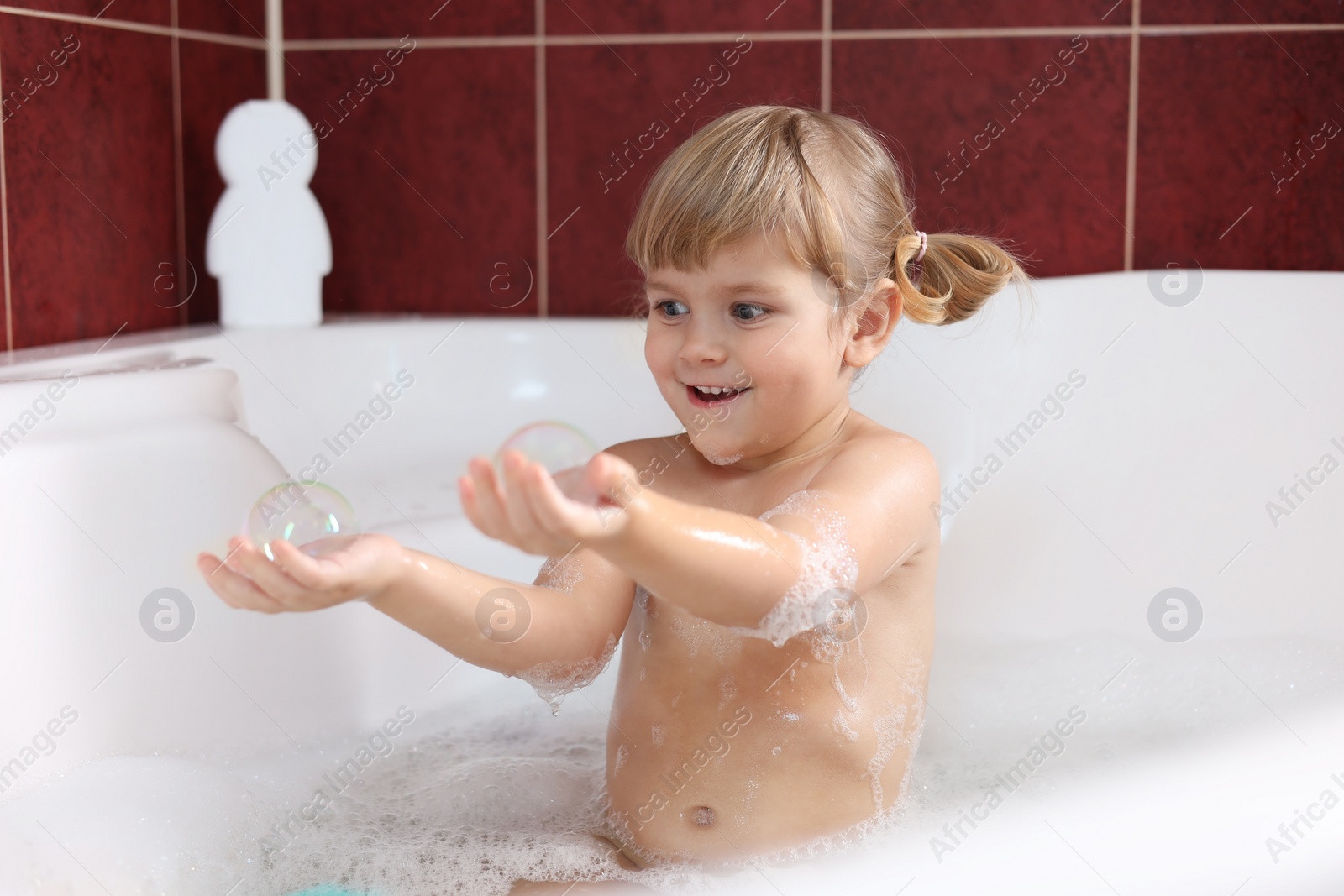 Photo of Happy girl having fun in bathtub at home