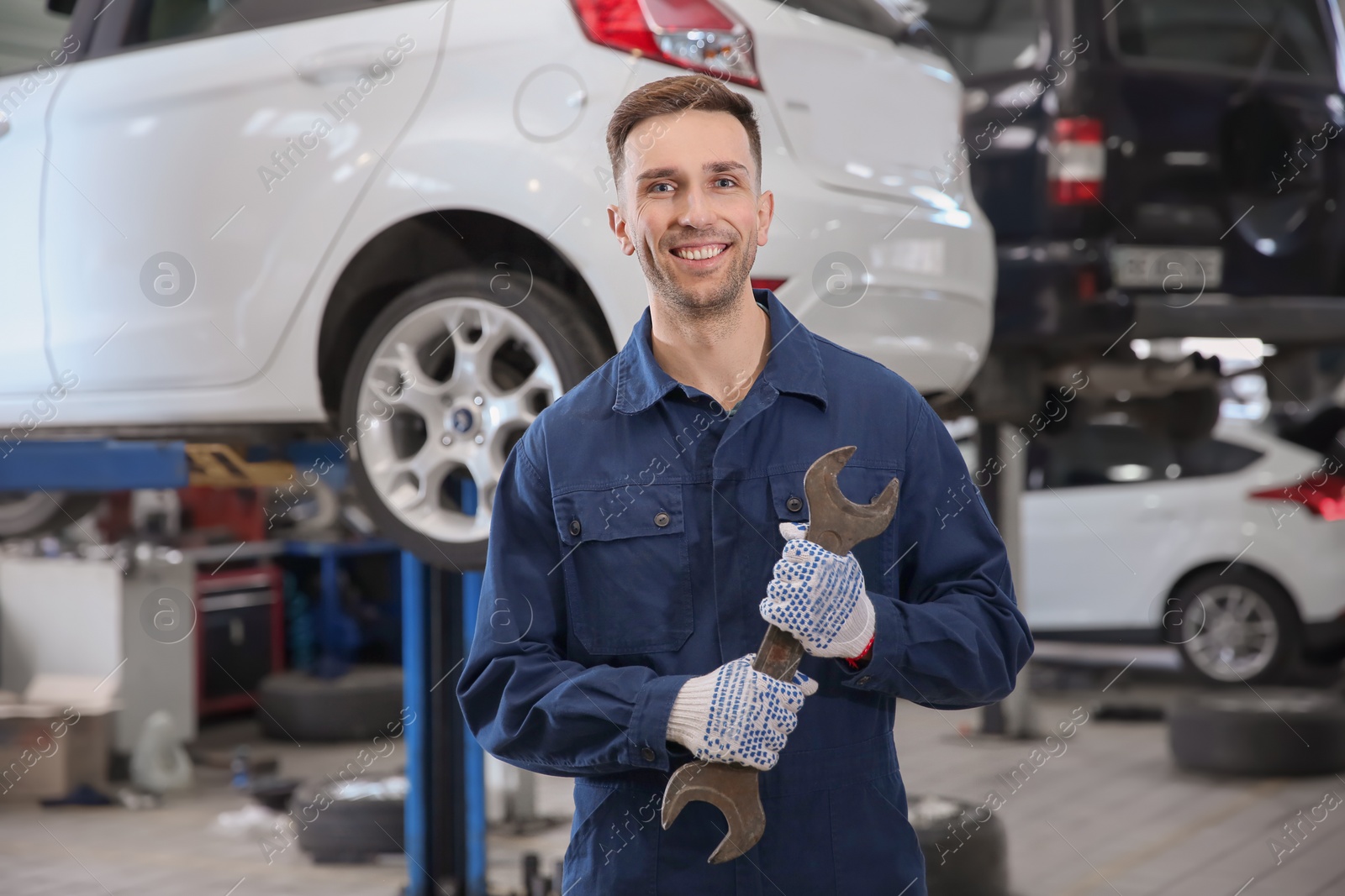 Photo of Young mechanic with wrench at tire service