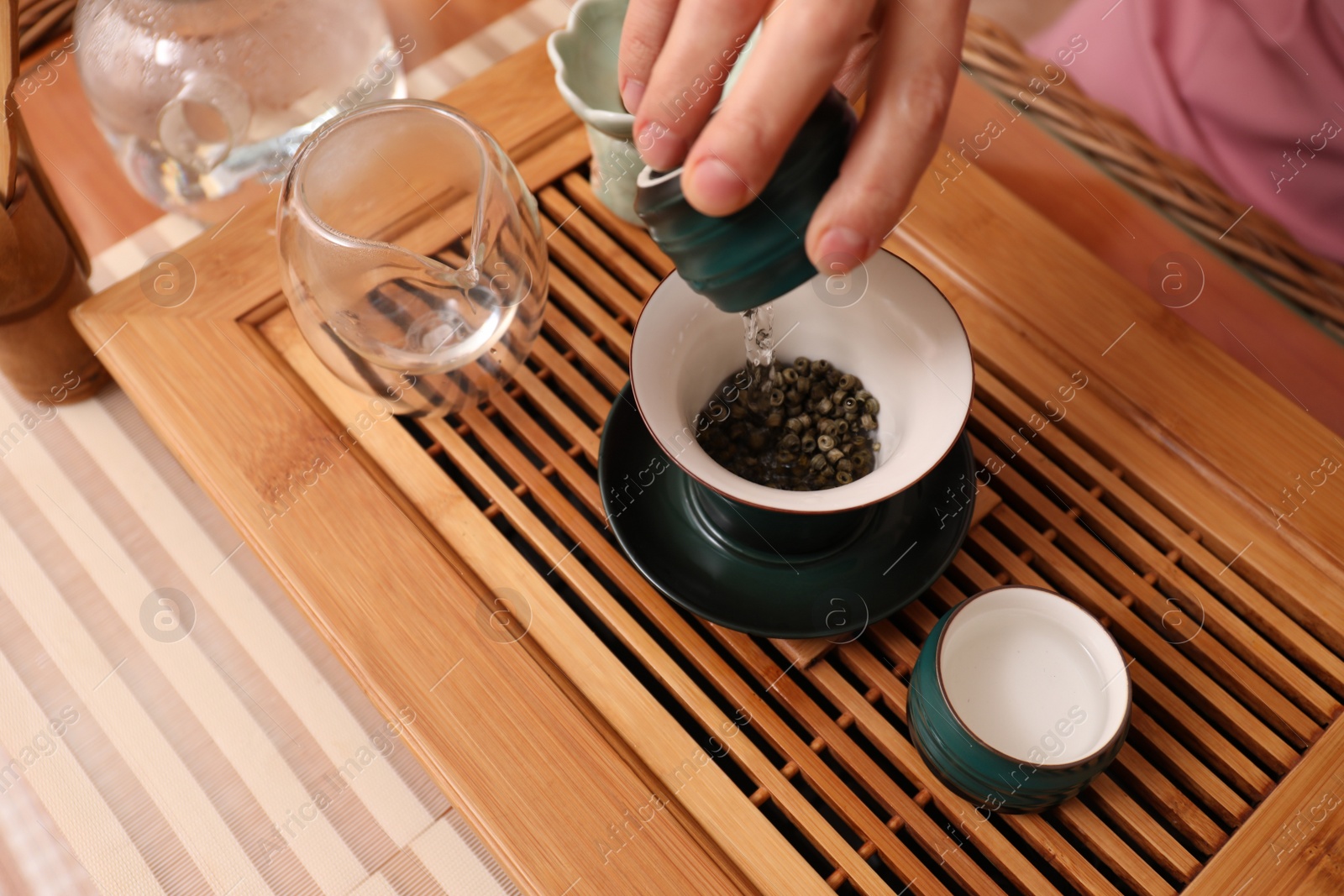 Photo of Master conducting traditional tea ceremony at table, closeup