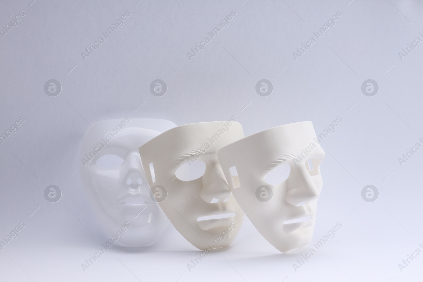Photo of Plastic face masks on white background. Theatrical performance