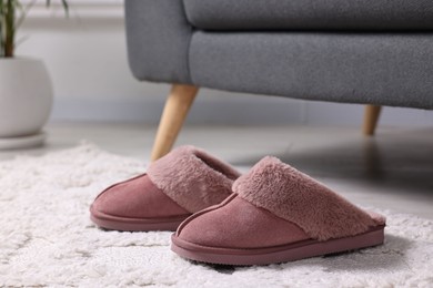 Pink soft slippers on carpet indoors, closeup