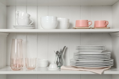 White shelving unit with set of dishware