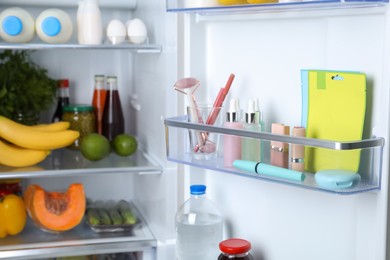 Photo of Storage of cosmetics in refrigerator door bin next to groceries