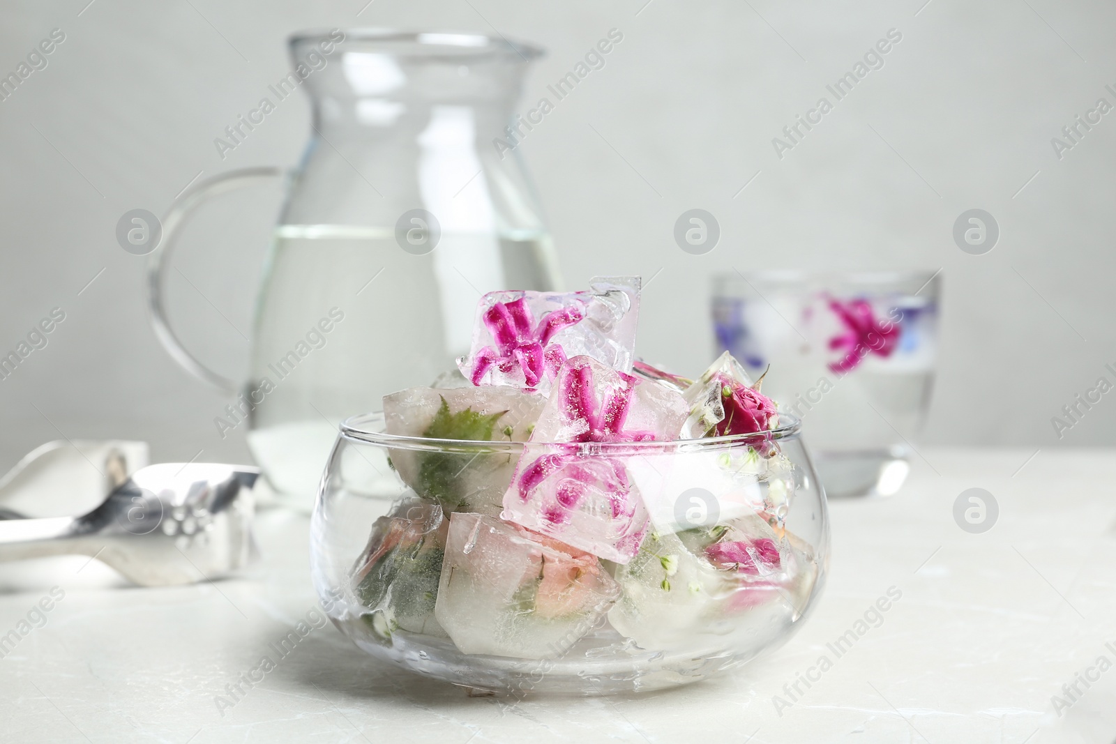 Photo of Glass bowl of floral ice cubes on table