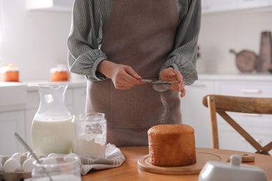 Photo of Young woman making traditional Easter cake in kitchen, closeup