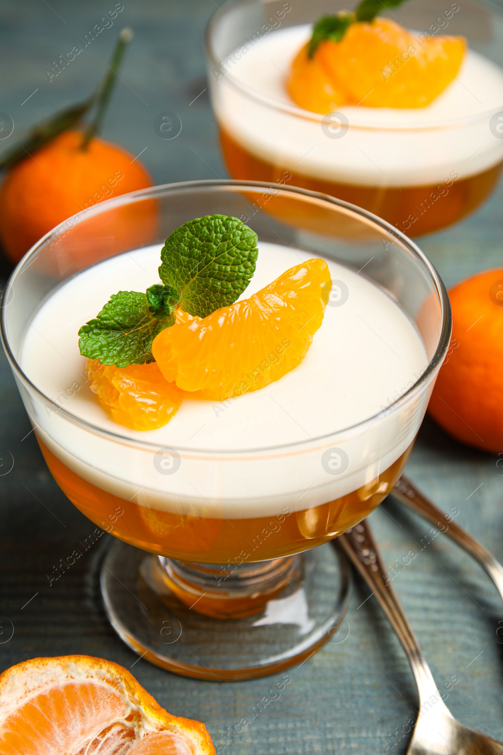 Photo of Delicious tangerine jelly on light blue wooden table, closeup