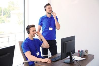 Photo of Technical support operators with headsets at workplace