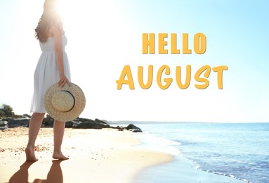Image of Hello August. Young woman with hat walking on beach near sea