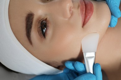 Young woman during face peeling procedure in salon, closeup