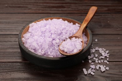 Photo of Bowl and spoon with violet sea salt on wooden table