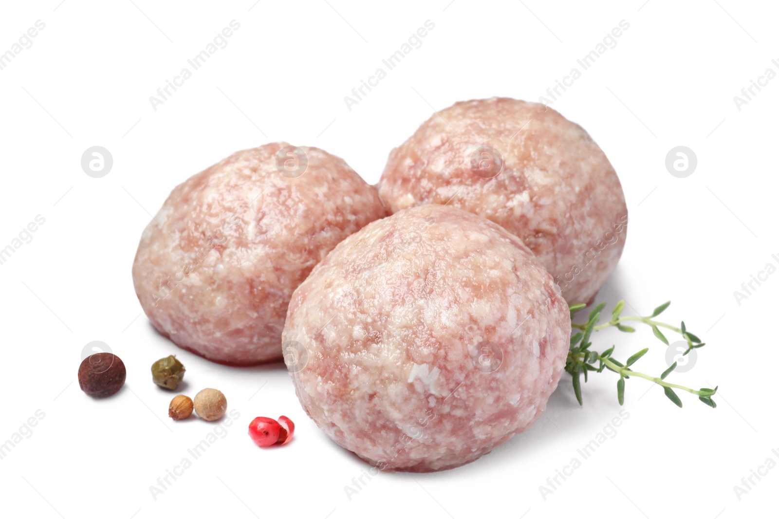 Photo of Three fresh raw meatballs with thyme and spices on white background