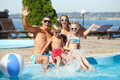 Happy family at poolside on sunny summer day