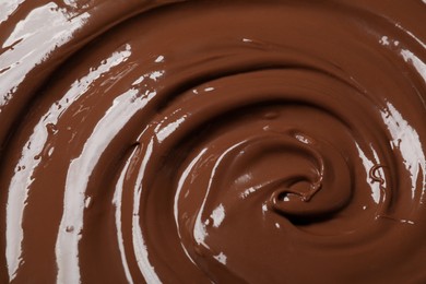 Photo of Tasty milk chocolate paste as background, closeup