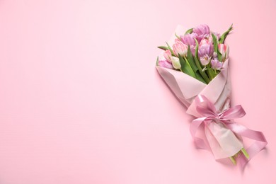 Beautiful bouquet of colorful tulip flowers on pink background, top view. Space for text