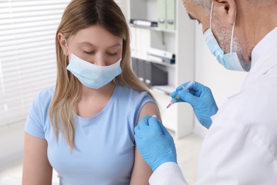 Doctor giving hepatitis vaccine to patient in clinic