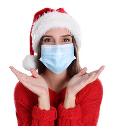 Photo of Pretty woman in Santa hat and medical mask on white background