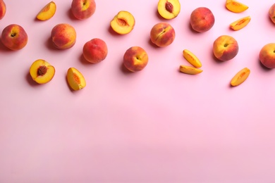 Photo of Fresh ripe peaches on pink background, flat lay. Space for text