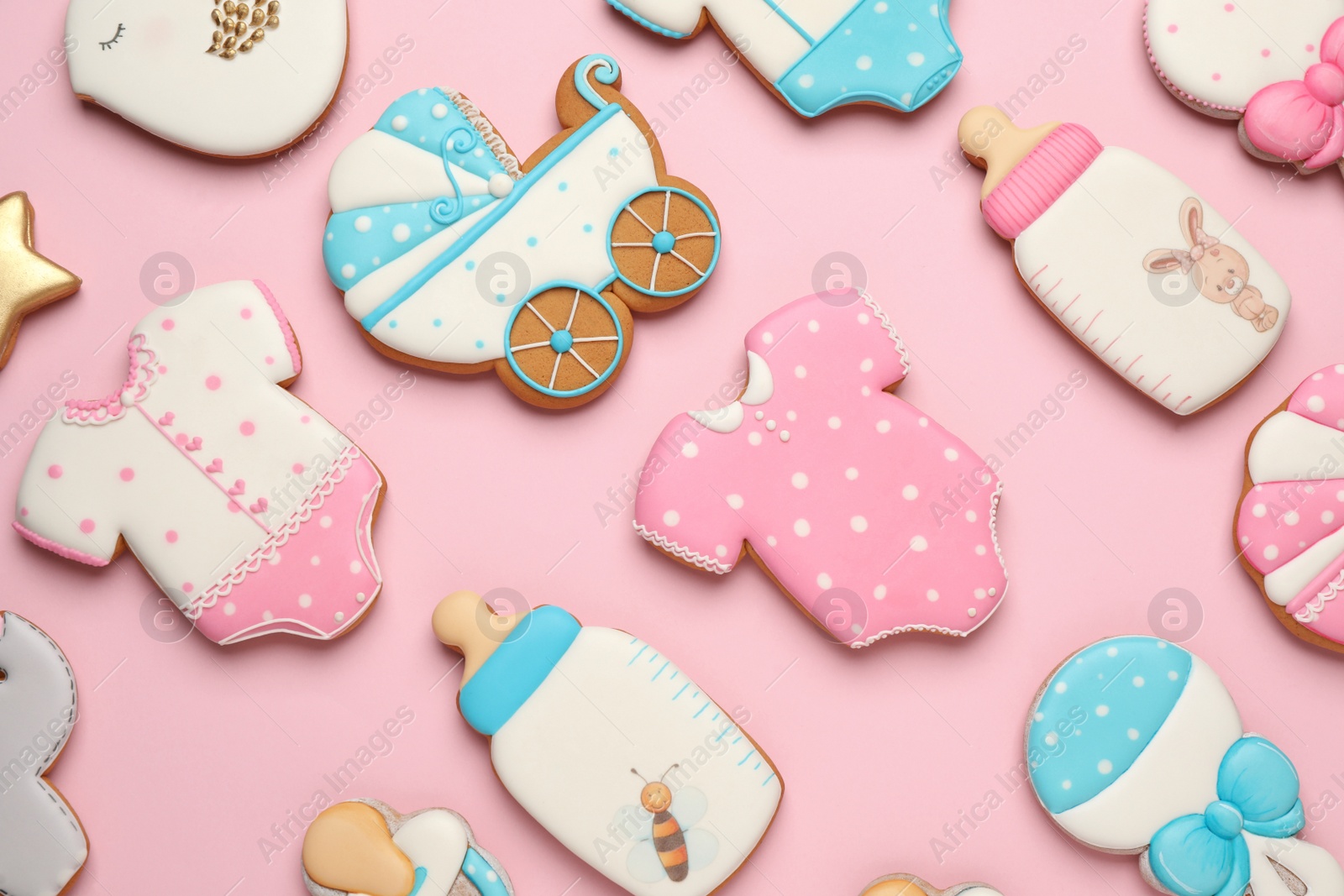 Photo of Set of baby shower cookies on light pink background, flat lay