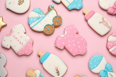 Photo of Set of baby shower cookies on light pink background, flat lay