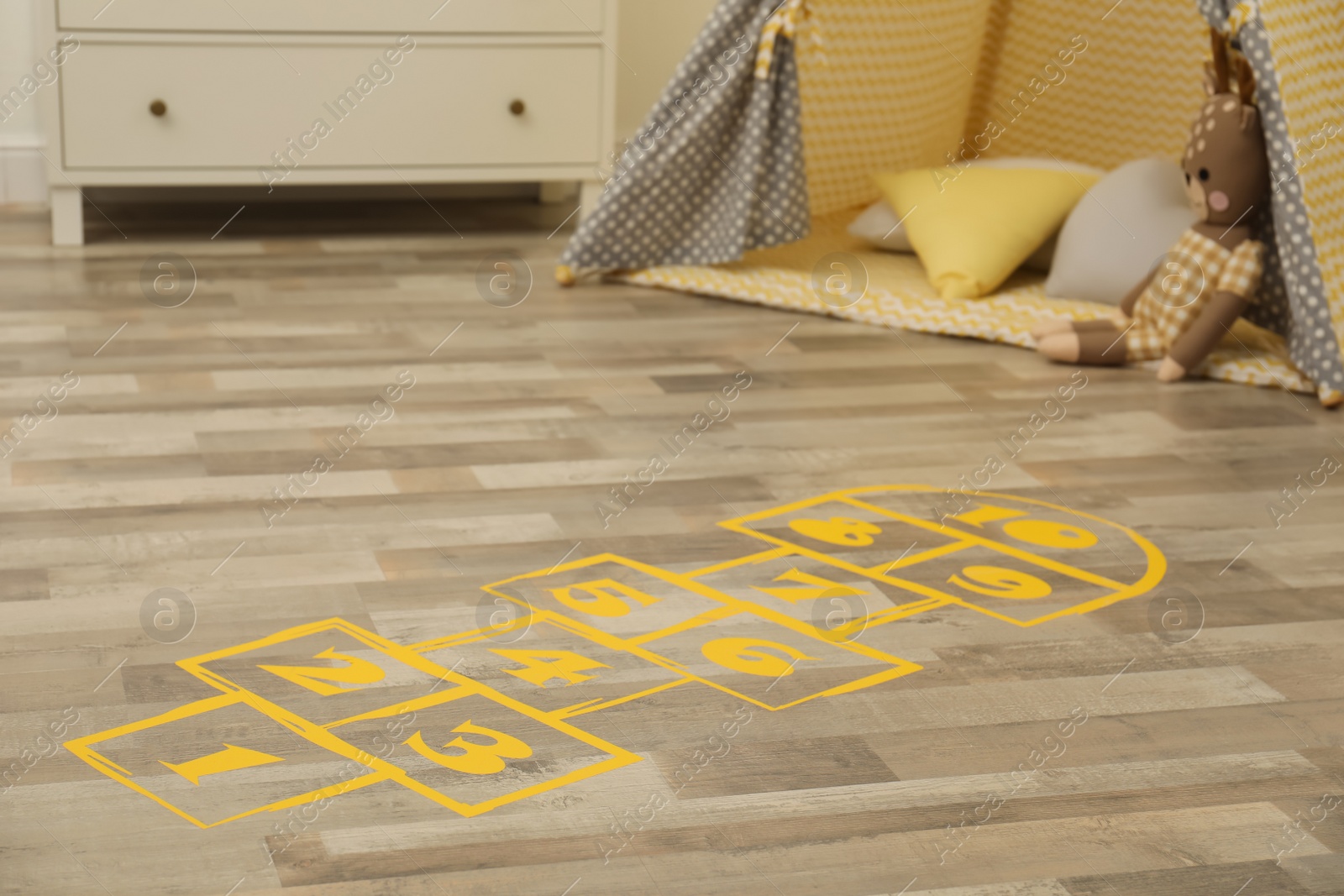 Photo of Yellow hopscotch floor sticker in room at home